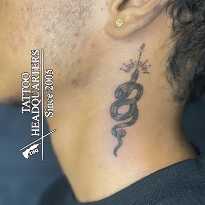 A classic gold stud in the earlobe. This client also got a fine-line snake tattoo on their neck, showcasing how we can help you combine different forms of body art.