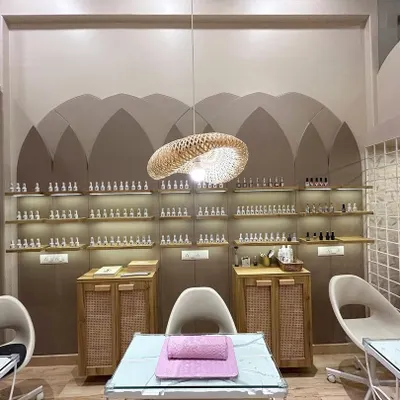 Welcome to our nail haven. This wide view shows our manicure stations and the extensive wall of polishes, all set up to give you a comfortable and luxurious experience.