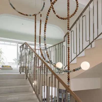 The LUNA light installation, a collaboration with Mother Gone Mad, cascades down the stairwell of Eden House. The wooden and ceramic beads create a natural, earthy feel, while the glowing orbs add a touch of magic.