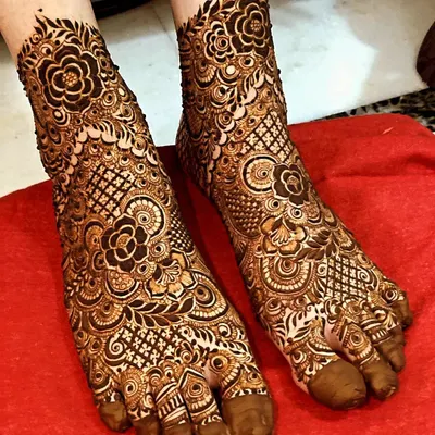 This is a perfect example of full-coverage bridal foot mehendi. The design is dense with floral and net patterns, covering the entire foot for a rich and traditional look.