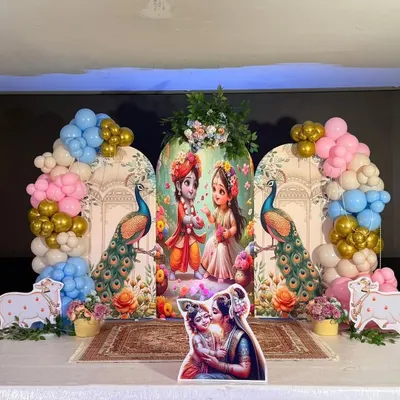 Celebrating Janmashtami with a divine touch. We created this beautiful stage setup featuring Radha and Krishna, decorated with peacock elements and colorful balloon arches in pastel and gold.