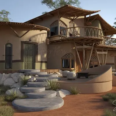 The guest units at Driftwood are designed to feel like private sanctuaries nestled in nature. This view shows the organic forms of the building, with its curved walls and thatched roofing, rising from the landscape. The stone steps and earthen patio blur the boundary between inside and out.