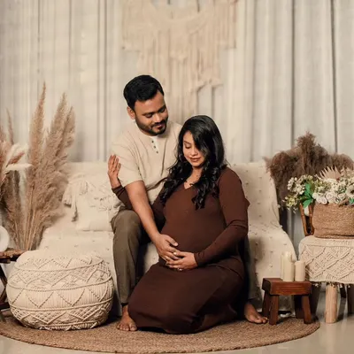 A full view of my cozy, bohemian-themed studio setup, featuring a couple in earth tones surrounded by pampas grass, macrame, and soft lighting.