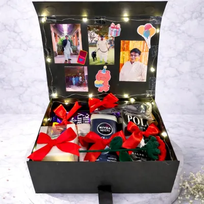 This birthday hamper is a surprise waiting to happen. The box lid is lined with photos and fairy lights, and the inside is filled with chocolates and other gifts for him.
