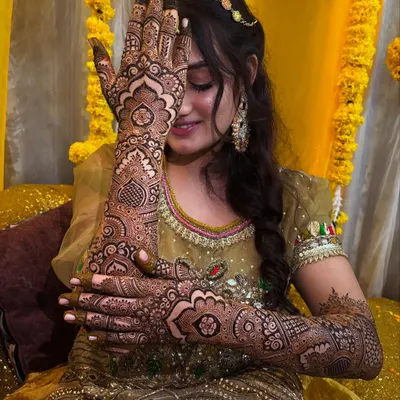 A beautiful bride showing off her intricate Pakistani back-hand design. This style is defined by its fine lines and detailed, full-coverage patterns.