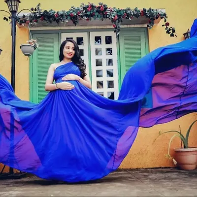 The incredible royal blue fabric of this flying gown creates a wave of color. This shot demonstrates the stunning visual impact these gowns have, perfect for a one-of-a-kind maternity portrait.