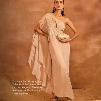 The Talia Kurti Set is my modern interpretation of Indian wear. It features a one-shoulder kurti with a striking cutout and floral embroidery, paired with sleek pants for a sophisticated silhouette.