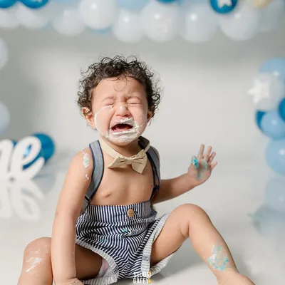 Sometimes a cake smash is just too much excitement! This photo captures the hilarious and very real tears that can happen during a first birthday celebration, a memory to laugh about for years.