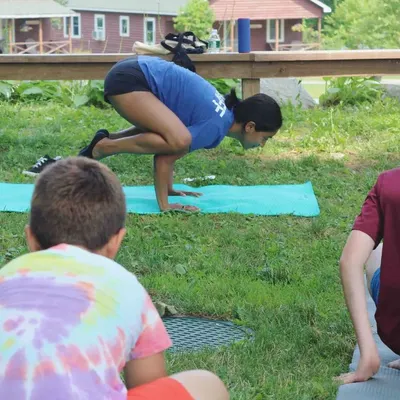 A different angle of our Bakasana practice. You can see the kids are fully engaged, watching and learning. I always demonstrate poses first to show them what's possible, creating a supportive 'we're in this together' vibe.