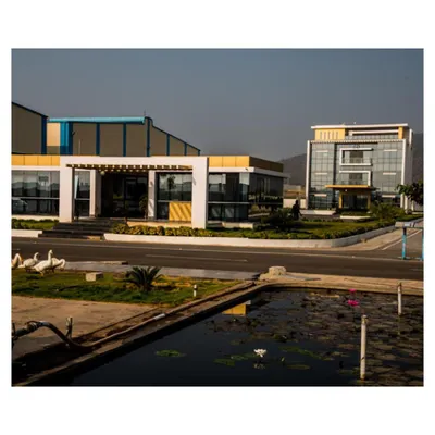 A view of the Krishna Sai Granites campus, showcasing the relationship between the main processing facility and the contemporary admin block. We integrated landscape elements like a water feature to soften the industrial context and create a more pleasant working environment.
