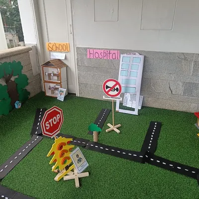 This is our miniature community, set up for a month-long exploration of homes and neighborhoods. It includes a school, hospital, and roads, providing a rich environment for imaginative play.