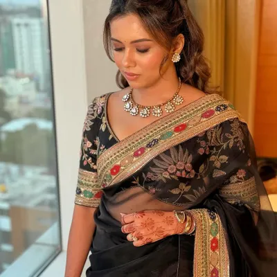 The definition of timeless luxury. This soft glam look with dewy skin was created to complement a stunning black Sabyasachi saree, perfect for an elegant reception.