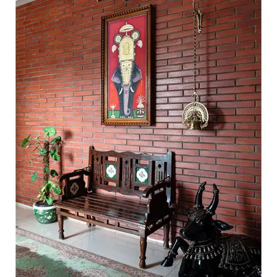 The private foyer welcomes you with a gorgeous brick-clad wall and a traditional Tanjore painting of a tusker elephant. This space immediately introduces the home's theme of warmth, art, and cultural heritage.