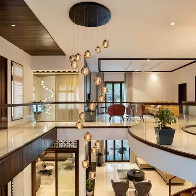 Looking down from the second-floor gallery, you can appreciate the scale of this open-concept home. The spiral chandelier cascades through the double-height void, connecting the upper and lower levels into one cohesive, light-filled space.