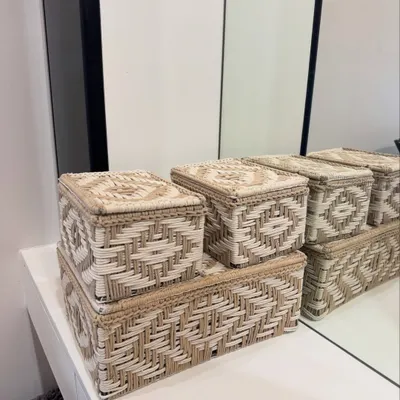 Our set of three woven storage boxes, shown here on a dresser. They are perfect for organizing jewelry, makeup, or other small essentials in a stylish way.