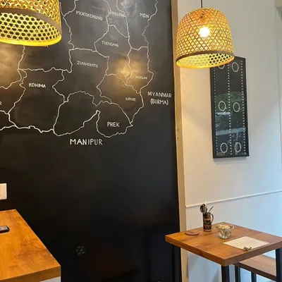 A quiet corner of our restaurant, featuring the hand-drawn map of Nagaland on a blackboard wall. This map is a tribute to our roots and a conversation starter for many of our guests.