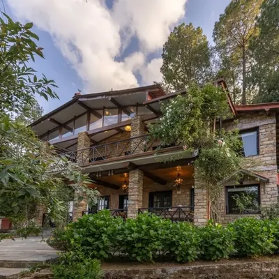The exterior of our Buransh Terraces project, a mountain home built with local stone and designed to feel like a natural extension of the Himalayan landscape. The multi-level terraces and large windows maximize the stunning views.