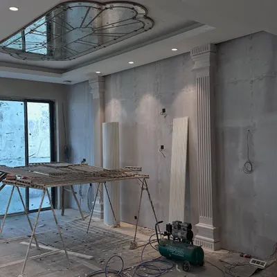 Before: The living room of our Gulshan Dynasty project during the initial civil work phase, with structural elements like pillars and ceiling details being put in place.
