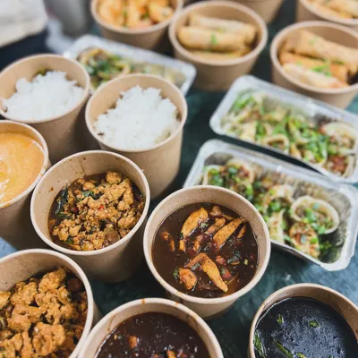 A large Asian food delivery order, ready to go. This spread includes our popular Thai curries, rice, noodles, and appetizers, all packed and ready to be enjoyed at home.