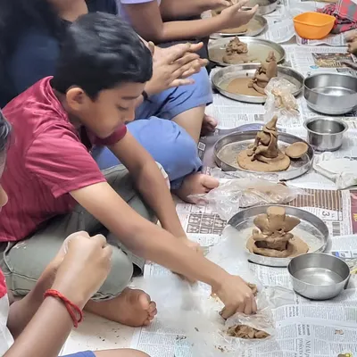 A young artist deeply focused on sculpting his Ganesha idol from clay. These tactile activities are wonderful for developing fine motor skills and concentration.
