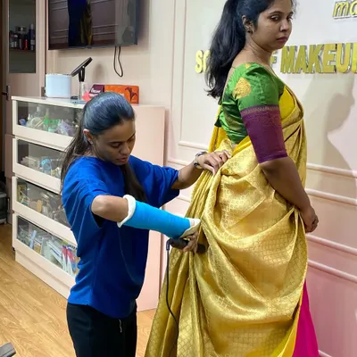 Dedication in action. This student, even with a cast on her arm, is determined to master the art of saree draping. It's this passion that makes a great artist.