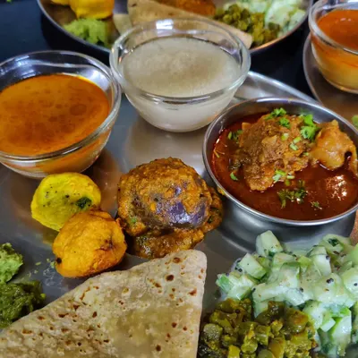 This is a true Kolhapuri thali, packed with a variety of dishes like Bharlela Vanga, zesty koshimbir, and rich mutton curry. This is the authentic, flavourful jevan (meal) I grew up eating.