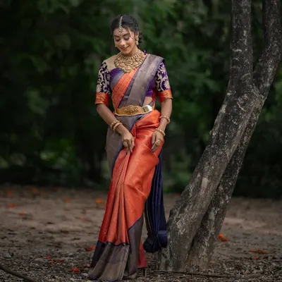For the bride who wants tradition with a touch of glam, this bright orange and purple Kancheevaram silk beauty is made to dazzle.