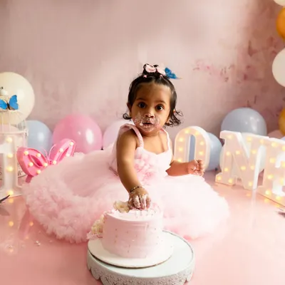 The cake smash begins. This little one is getting her first taste of birthday cake during her butterfly themed first birthday photoshoot in my Navi Mumbai studio.