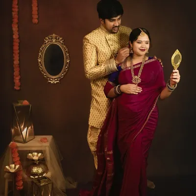 A beautiful moment from a traditional maternity session. The husband helps his wife with her earring, a small, intimate gesture that speaks of their love and partnership.