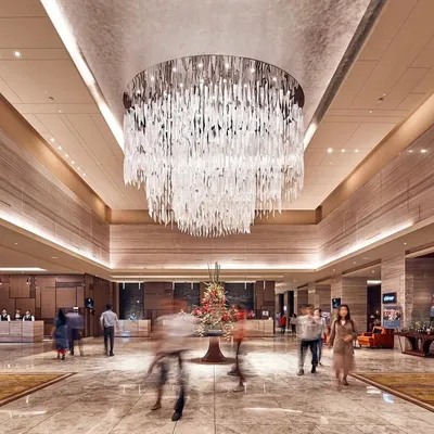 The lobby of the Sheraton, Bangalore, is defined by its soaring ceiling and this spectacular custom chandelier. We use such statement pieces to create a sense of arrival and luxury in our hotel interior designs.