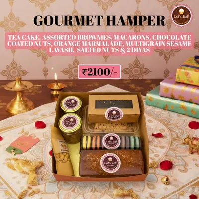 My grand Diwali Gourmet Hamper, featuring a full spread of handmade sweets and savouries. It includes a tea cake, assorted brownies, macarons, chocolate nuts, orange marmalade, multigrain lavash, salted nuts, and two decorative diyas.