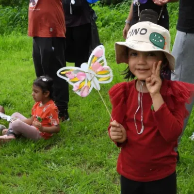 A proud five-year-old shows off her handmade butterfly craft during her nature-themed birthday party on the outskirts of Mumbai. We love seeing families choose muddy, meaningful experiences to celebrate milestones.