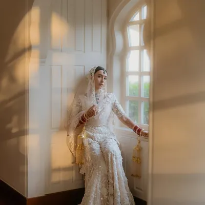 A moment of quiet solitude for the bride, Sejal, by the window. The beautiful play of natural light and her elegant white chikankari lehenga created a portrait that is both serene and absolutely timeless.