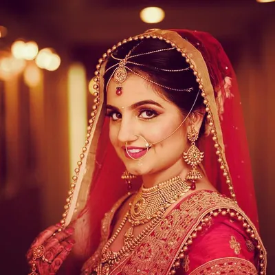 A classic bridal portrait against a beautifully blurred background. Using a Nikon 70-200mm lens, I created significant bokeh, making the bride and her stunning red lehenga the complete focus. The direct gaze creates a powerful connection.