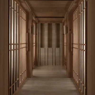 A meditative corridor at the Be Well wellness center, lined with rhythmic, wood-framed screens. The design uses symmetry and a restricted material palette to create a powerful sense of calm and order.
