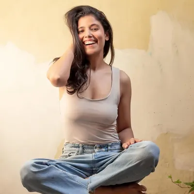 A genuine, laughing portrait in a casual tank top and jeans. This shot captures my natural, happy energy, perfect for relatable lifestyle content.