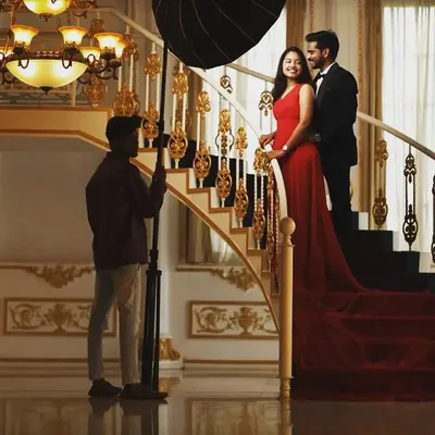 A behind the scenes look at a photoshoot in a grand location. Our team and the photographers work together to get the perfect shot of our red trail gown.