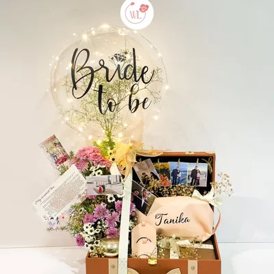 The ultimate bridal bliss hamper. This vintage-style trunk is filled with personalized gifts, a floral arrangement, cherished photos, and a "Bride to be" balloon to make her feel truly celebrated.