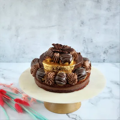 This is our Desire 3 Cake, a true chocolate adventure. We pair dark couverture chocolate with our house-made dacquoise, rich mousse, and creamy panna cotta, then garnish it with 99% pure gold varak for a touch of luxury.