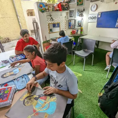 A wide view of my drawing class in session. Students are busy working on their individual pieces, using reference images to create stunning portraits with oil pastels.