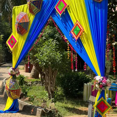 The entrance to Niharika and Ashish's Mehandi celebration. We used vibrant blue and yellow drapes, accented with traditional Rajasthani umbrellas and hangings, to create a festive and colorful welcome.