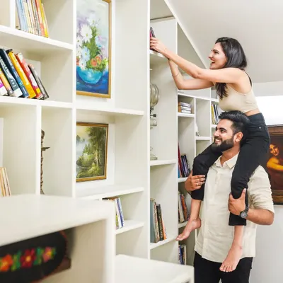 A pre-wedding shoot should be fun. This playful moment, with her on his shoulders reaching for a book, is full of genuine laughter and joy. It’s a perfect example of how I capture your real personalities during an indoor couple shoot.