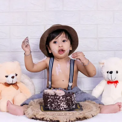 The aftermath of a successful cake smash. This little one is enjoying every last bit of his first birthday cake.