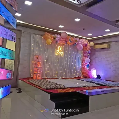 A full view of our 'Oh Baby' themed baby shower stage decoration. The setup includes a fairy light curtain, a pastel balloon arrangement, and an illuminated 'Oh Baby' neon sign.