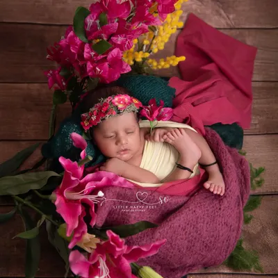 Wrapped in love and surrounded by vibrant pink and yellow flowers. This colorful, floral-rich setup is perfect for welcoming a spring or summer baby.
