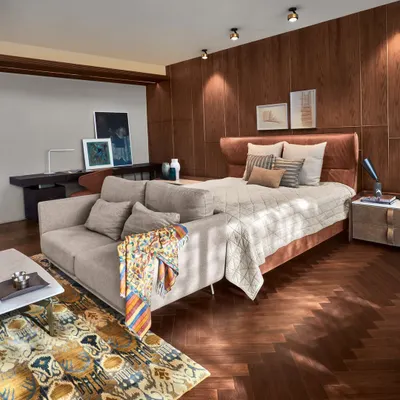 A serene bedroom at the Baid Residence, featuring a luxurious rug from Jaipur Rugs and elegant Tato lamps from Lightbox Delhi. The space is a harmonious blend of comfort, style, and curated art.