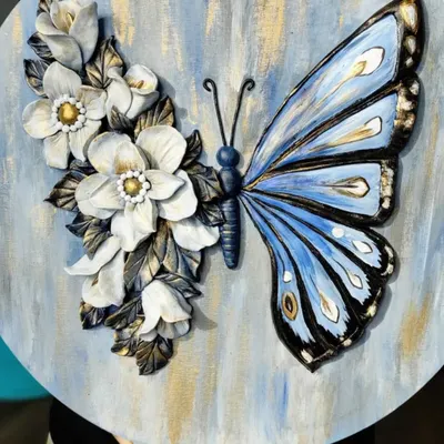 A stunning example of canvas sculpting, where a butterfly's wing is painted and the other is crafted from 3D floral elements. Learn to combine painting and sculpting in our mixed-media workshops.
