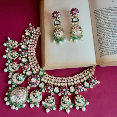 A statement Kundan set that pulls an entire outfit together. The combination of uncut stones, emeralds, rubies, and pearls creates a rich, traditional look that is perfect for any festive or wedding occasion.