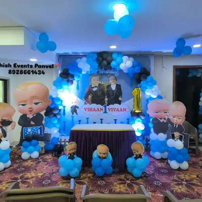 A complete Boss Baby themed stage for a first birthday party. This setup includes a main backdrop, life-sized character props, and coordinated balloon columns to create an immersive experience.