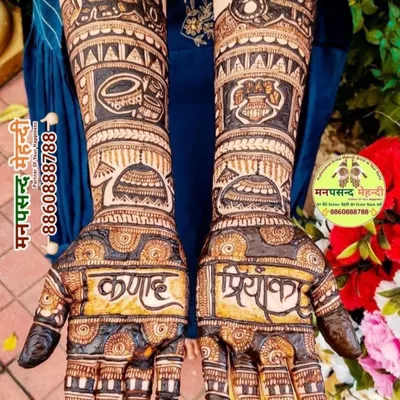 A bold and beautiful design where the couple's names, 'Kunal' and 'Priyanka', are the centerpiece of the palms. The design is complemented by traditional wedding symbols on the arms.